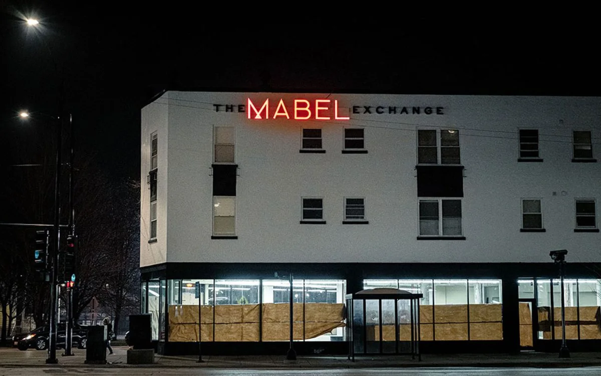 The Mabel Exchange at night, its red neon sign lit above Ridge Avenue